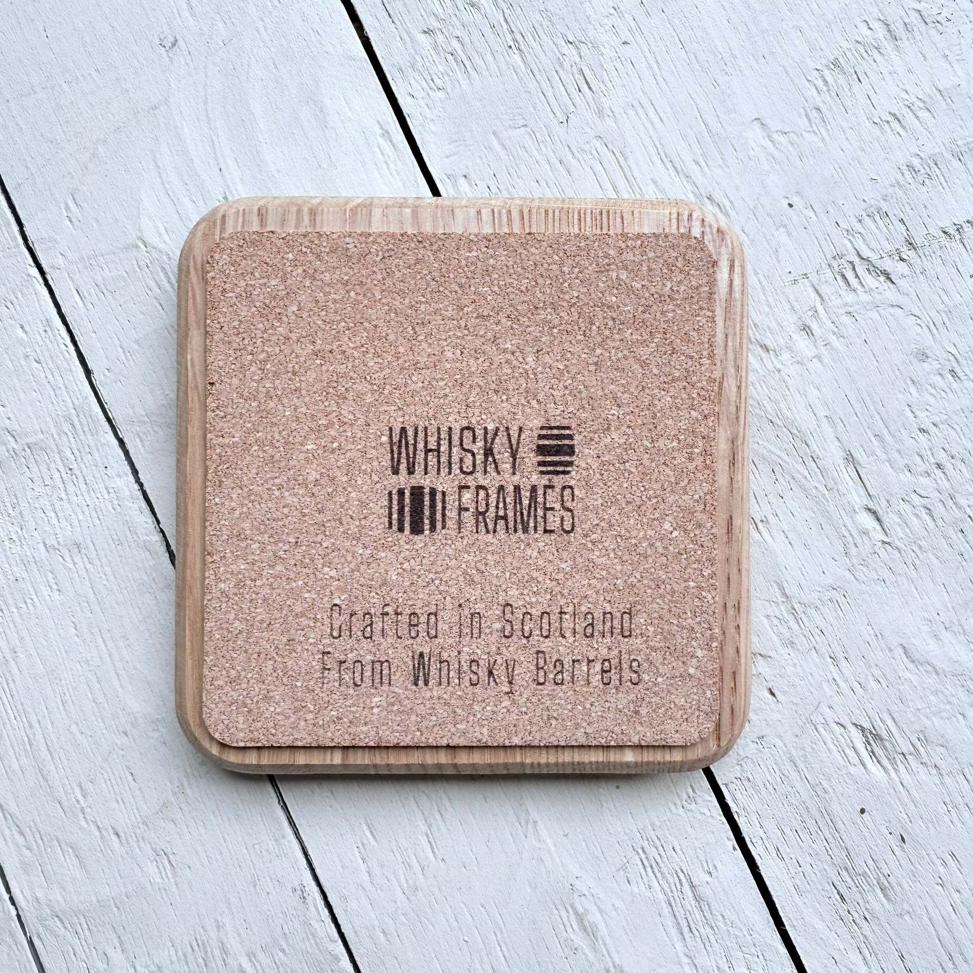 Back side of Wooden coaster with 'Whisky Frames' branding on cork
