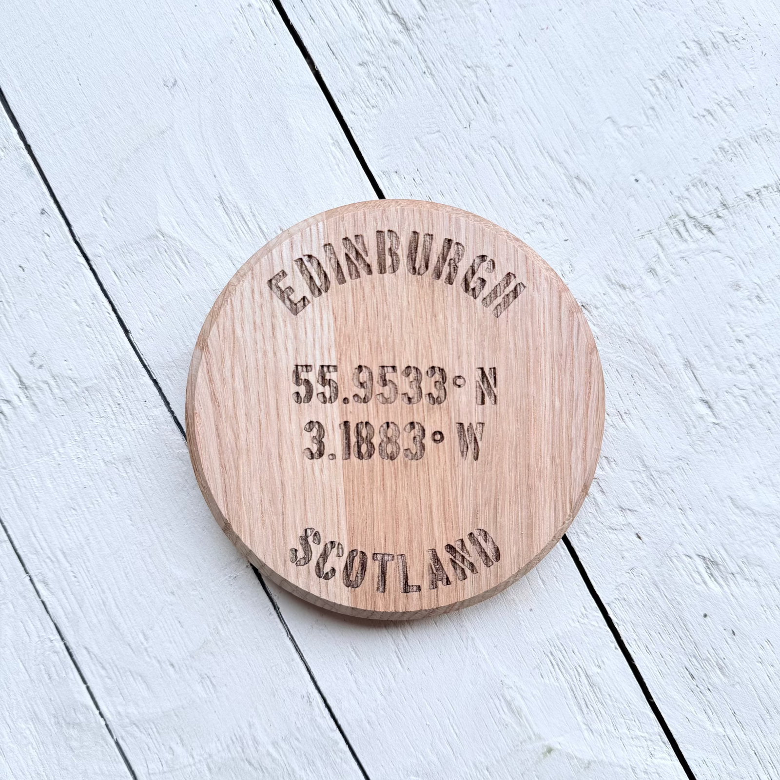 Barrel Oak Wooden coaster with engraved Edinburgh text and Coordinates on a white wooden surface