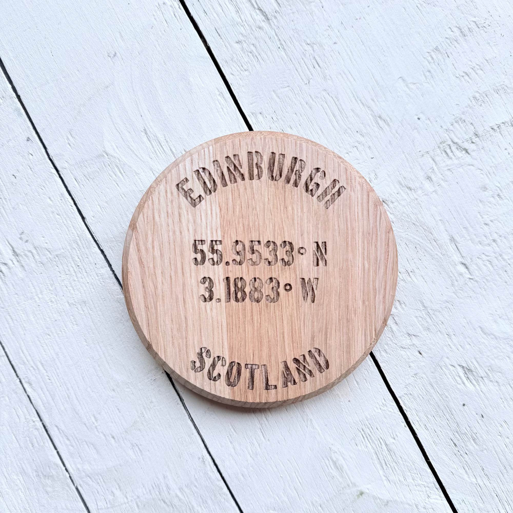 Barrel Oak Wooden coaster with a highland cow design on a light wooden 