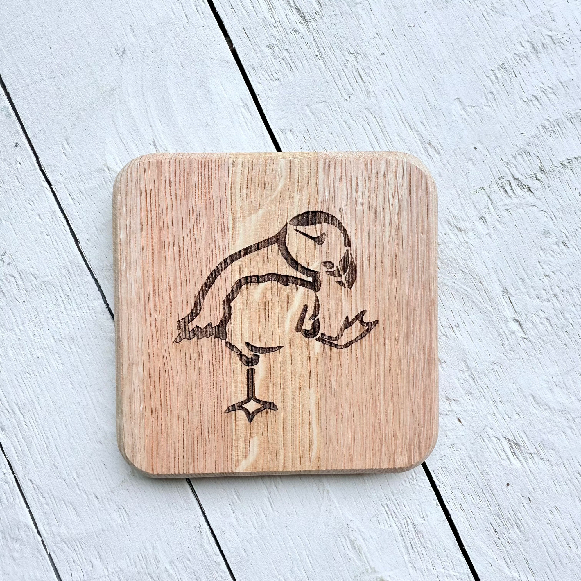 Barrel Oak Wooden coaster with a Puffin design on a light wooden surface