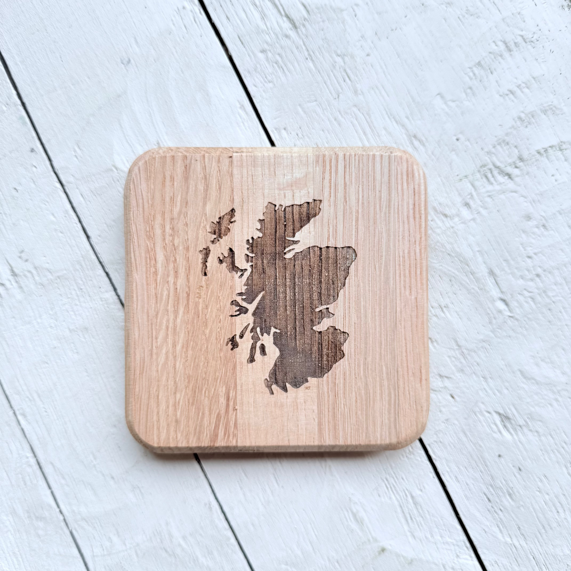 Barrel Oak Wooden coaster with laser-cut Scotland map design on a light wooden surface