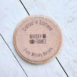 Wooden barrel oak circle coaster with 'Whisky Frames' branding on a cork backing.